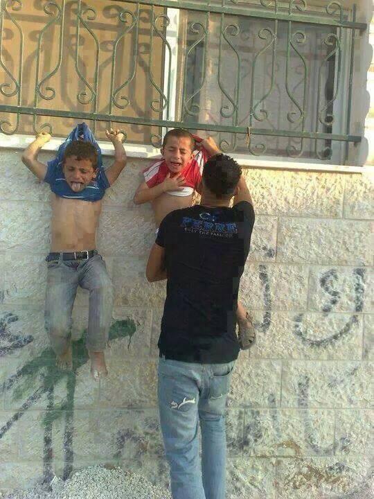 @AdamMilstein spread this photo on Twitter claiming it shows a "Hamas Terrorist" hanging "kids on a fence in front of a house to ensure the #IDF will not strike the building."